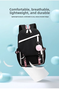 Detail of pink and black backpack featuring sport strap and plush ball keychain