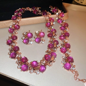 Detail of rose gold flower jewelry set with purple cat-eye stones and sparkling crystals