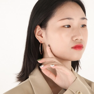 Close-up of elegant rose gold hoop earrings worn by a model for a minimalist look
