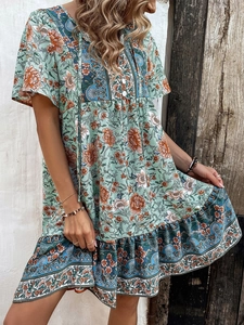 Detail of V-neck boho floral dress featuring buttons and mint green vintage patterns