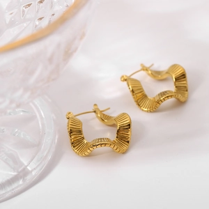 Macro detail of 18K gold plated stainless steel earrings with unique wavy texture