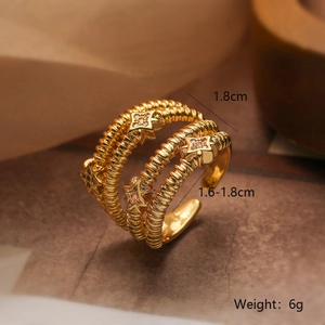 Detailed macro view of gold-plated layered ring with star engravings and zircons