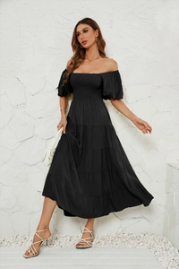 Détail de la manche bouffante et du corsage smocké sur une robe midi noire