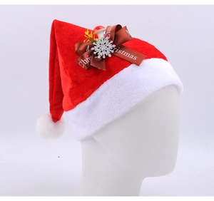 Detail of red plush Christmas hat with brown ribbon bow and silver snowflake ornament
