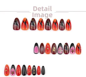 Detail of almond press-on nails with 3D metal roses and rhinestone cross decorations