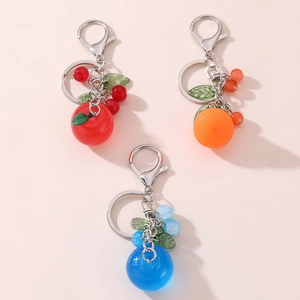 Close-up of colorful fruit-shaped keychains including apple, orange and berry charms