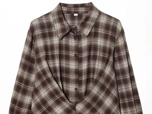 Close-up of brown and gray plaid flannel fabric with detailed side slit hem and stitching