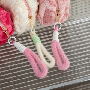 Close-up of plush heart bags showing soft lamb velvet texture and woven tassel zippers