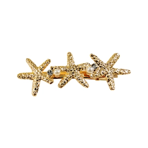 Detail of golden starfish hair clip with elegant pearl inlays and sparkling rhinestones