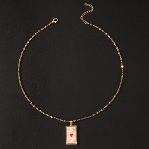 Detail of gold tarot card pendant necklace with red heart enamel and The Lovers engraving