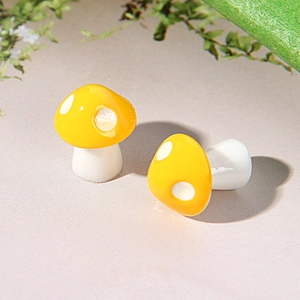 Macro shot of two miniature yellow resin mushrooms with white dots for micro landscape decor