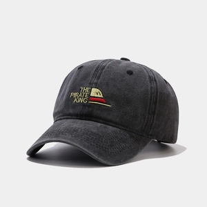 Detailed close-up of vintage washed gray cotton baseball cap with The Pirate King embroidery