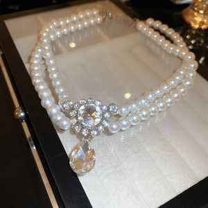 Macro shot of double-layered pearl necklace with detailed crystal teardrop pendant