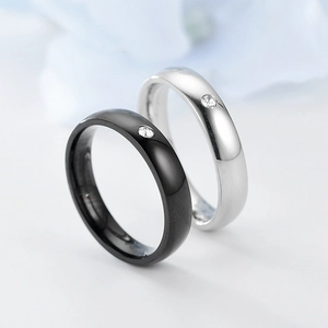 Macro shot of minimalist black and silver titanium steel rings with single diamond inlay