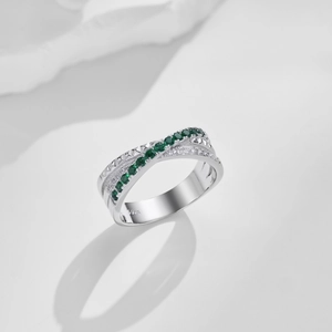 Detail of S925 sterling silver ring with green zircon stones on white marble surface
