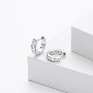 Macro shot of S925 sterling silver huggie earrings with sparkling white zirconia stones