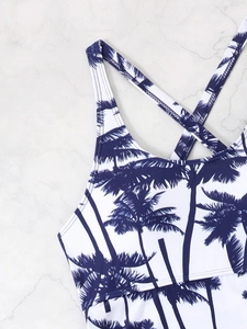 Detail of tropical palm tree print tankini with crisscross back straps and elastic fabric