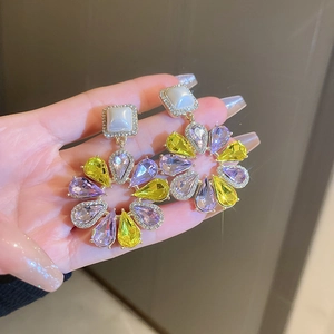 Detailed close-up of water drop floral earrings with purple and yellow crystals