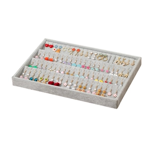 Gray velvet earring display tray with multiple slots for large jewelry storage