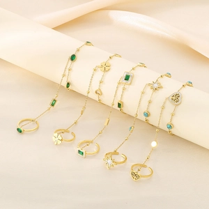 Detail of 18k gold plated finger bracelet showing clover and star charm pendants