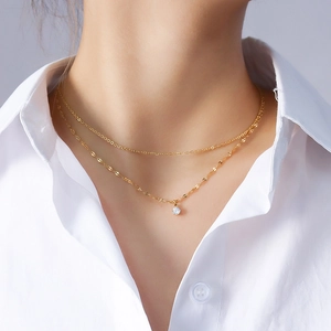 Double-layered 18K gold plated titanium necklace with zirconia pendant on a model