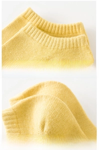 Close-up of elastic ribbed cuff and reinforced thick heel on yellow cotton sock