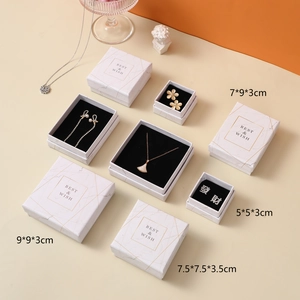 Detailed view of white marble jewelry boxes with gold foil branding in multiple sizes