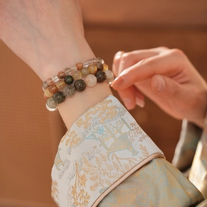 Gros plan d'un bracelet multicouche en perles de quartz naturel porté avec détails en cristal