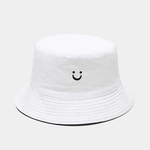 Detail of white cotton bucket hat featuring black smiley embroidery and inner lining