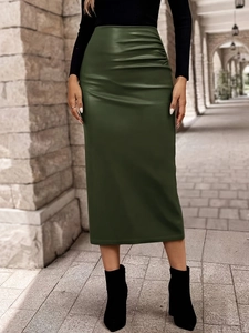Detail of dark green PU leather skirt showing high waist ruched side and sleek material