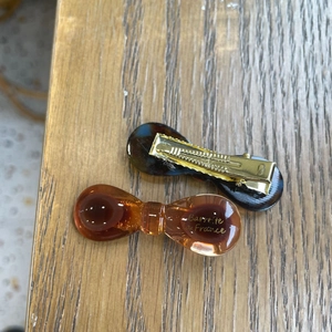 Close-up of amber and tortoiseshell duckbill hair clips with gold Barrette La France text