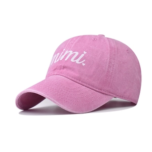 Detail of washed pink cotton baseball cap with white mimi script embroidery and heart