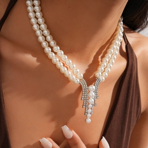 Detail of elegant double-layer faux pearl necklace with sparkling rhinestone tassels