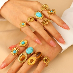Detail of vintage bohemian ring set with turquoise and sun patterns on model hands