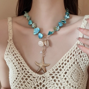 Detail of beach style necklace featuring turquoise beads, seashell and gold starfish