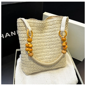 Detail of hand-woven beige straw bag with unique wooden bead and rope shoulder strap
