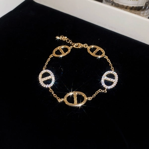 Detail of gold plated oval link bracelet with sparkling zircon stones on velvet background