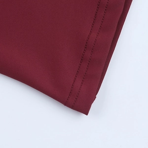 Detail of high-quality double-needle reinforced stitching on a deep red knitted dress