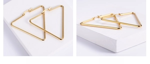 Macro view of geometric gold-toned triangle hoop earrings with polished steel finish