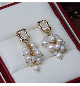 Detail of baroque freshwater pearl grape earrings with gold-plated zircon inlay