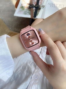 Detail of pink square fashion watch with silicone strap and moon phase dial on wrist