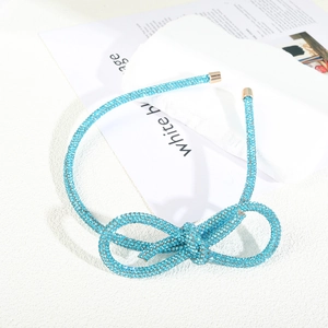 Sparkling light blue rhinestone bow headband with elegant gold-tone metal end caps