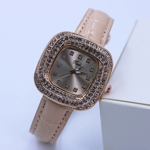 Macro shot of rose gold square watch dial with inlaid diamonds and Tadi logo details