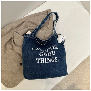 Détail du sac fourre-tout en denim bleu marine avec imprimé et porte-clé nuage