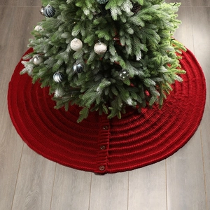 Close-up of red knitted Christmas tree skirt with decorative brown wooden buttons