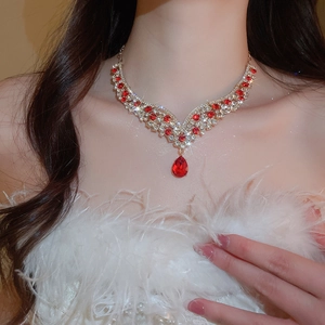 Detail view of vintage necklace with red teardrop pendant and crystal inlay on model