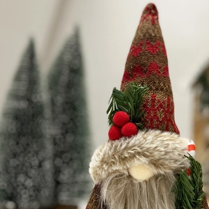 Detailed close-up of a Christmas gnome with brown knit hat and festive pine needles