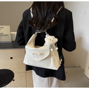 Close-up of off-white PU leather backpack featuring a matching bow and cloud plush charm