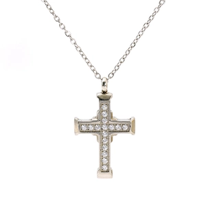 Close-up of a silver stainless steel cross pendant necklace with round clear gemstones