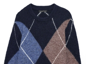 Detailed close-up of argyle knit pattern and soft wool texture on navy crewneck sweater